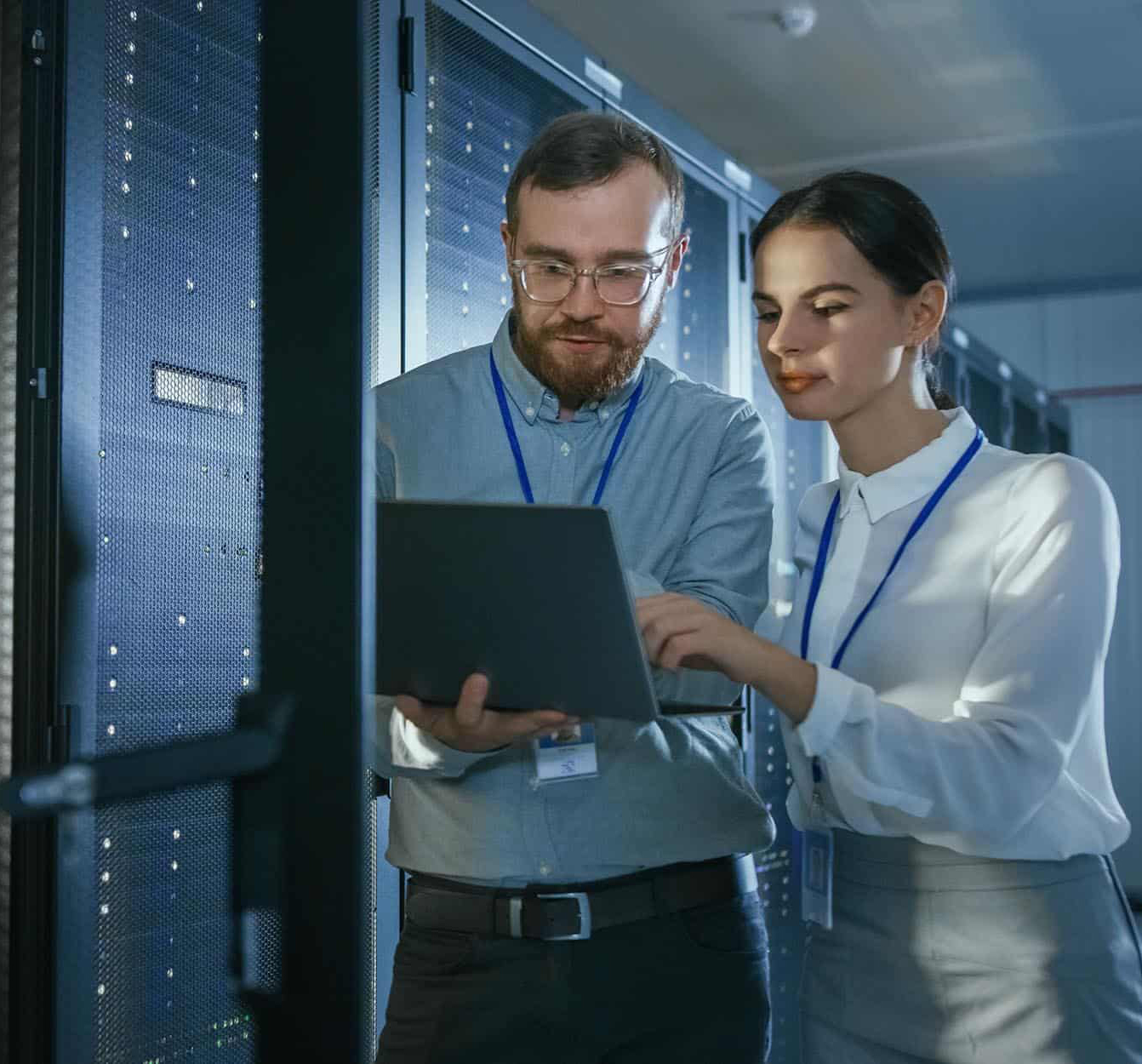 Two-professionals-analyzing-computer-in-data-center-narrow