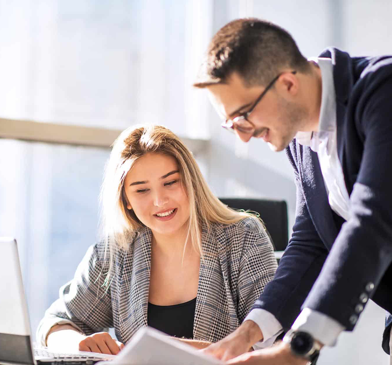 Two-workers-talking-at-desk-narrow
